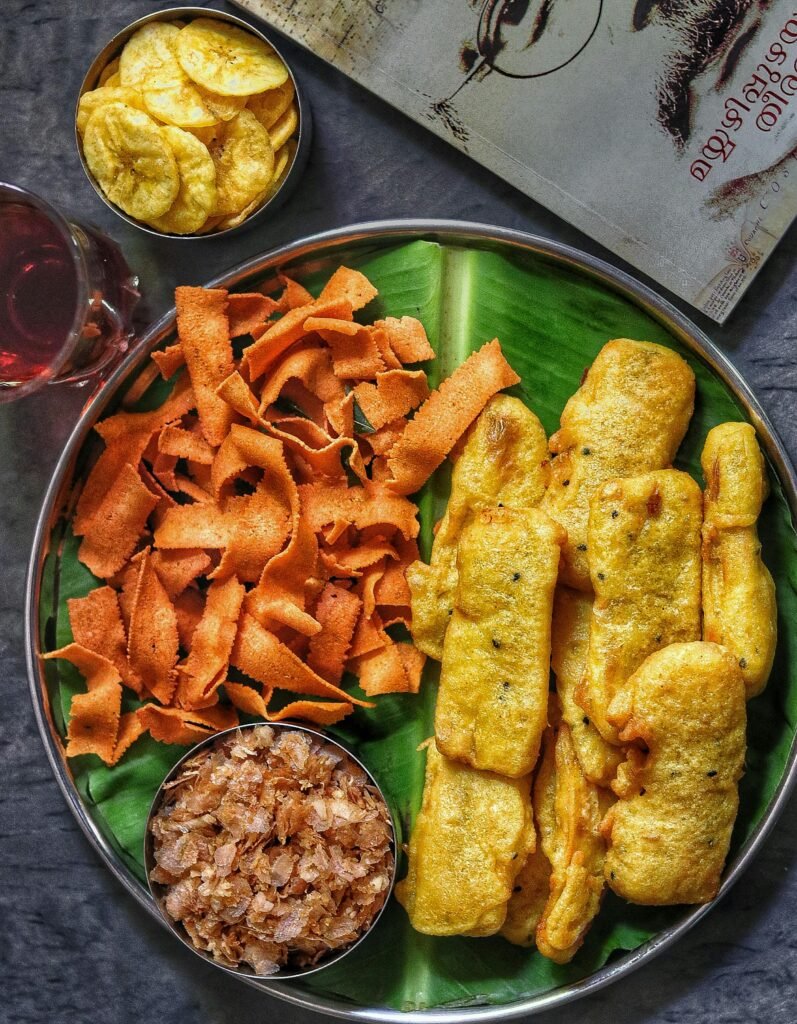 Authentic Indian snack platter featuring banana chips, pakoras, and chutney, served on a banana leaf.